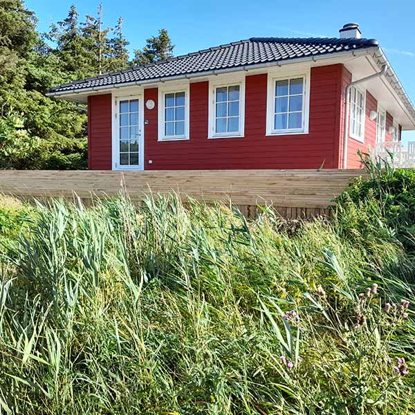 Plantekasse rundt om terrasse ved sommerhus.